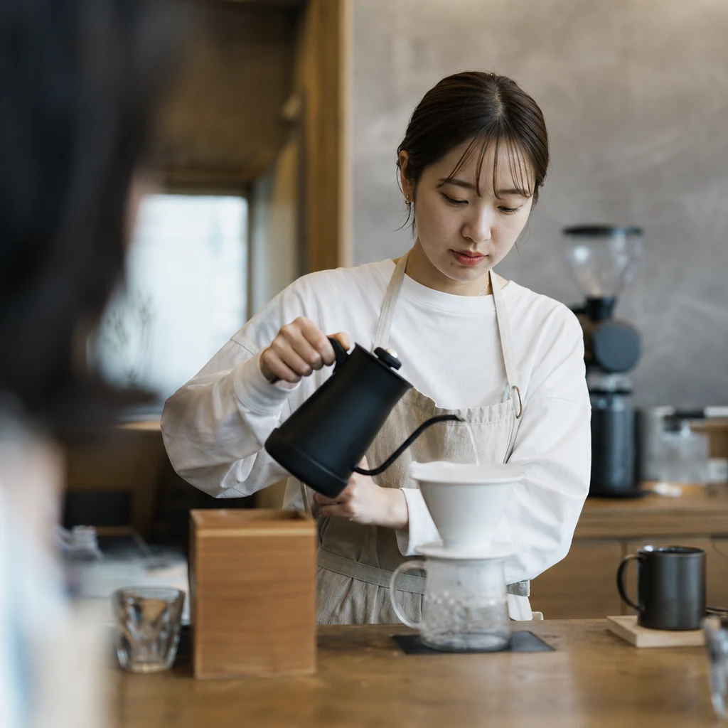 カフェでコーヒーを淹れるスタッフ